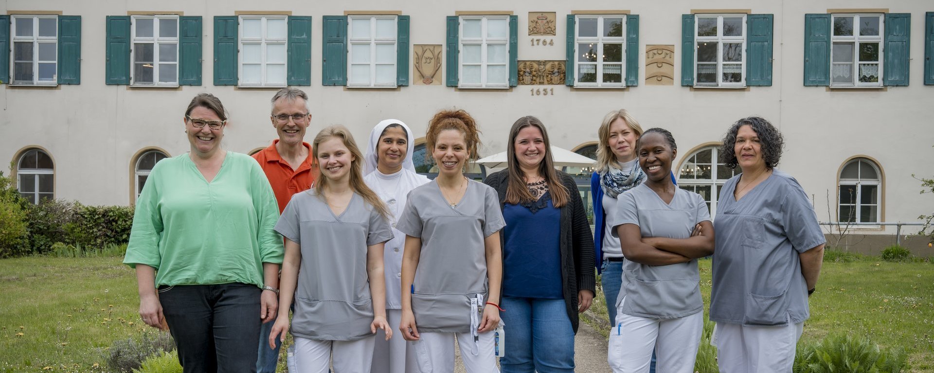 Ein Teil des Teams von Schloss Hochaltingen lacht in die Kamera.